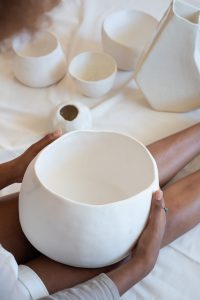femme tenant un bol de poterie